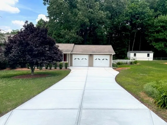 A long and straight two-car driveway leading up to a garage