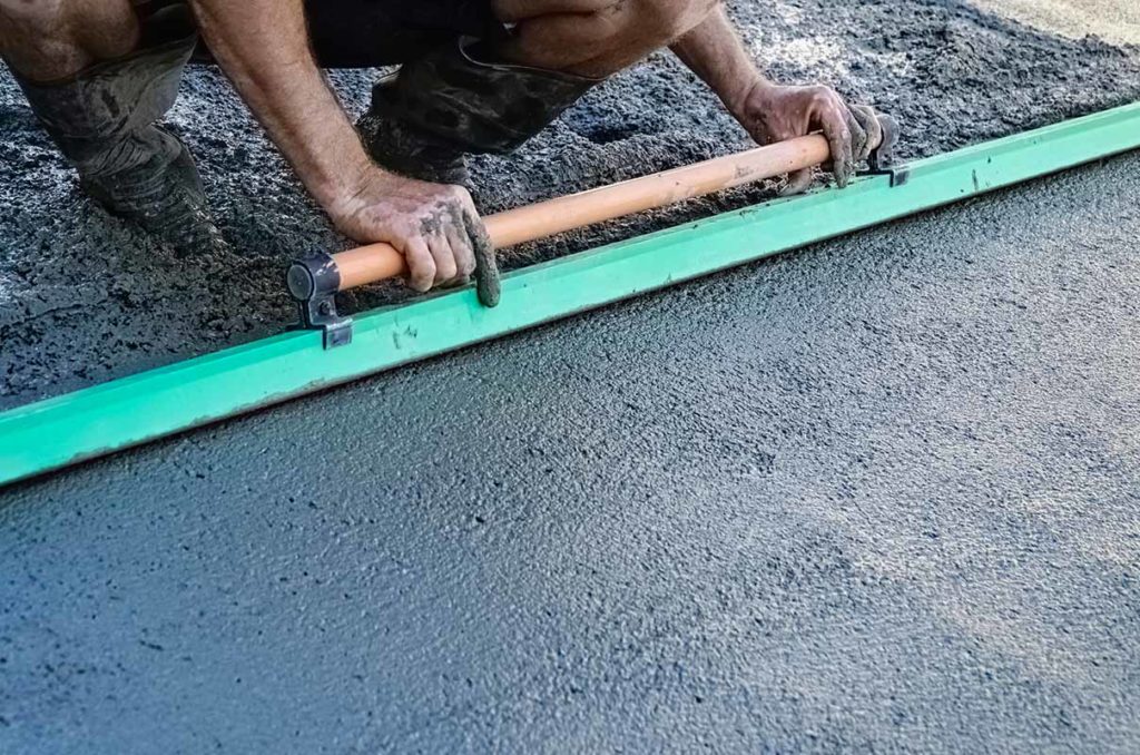 Concrete specialist using a floater on concrete driveway