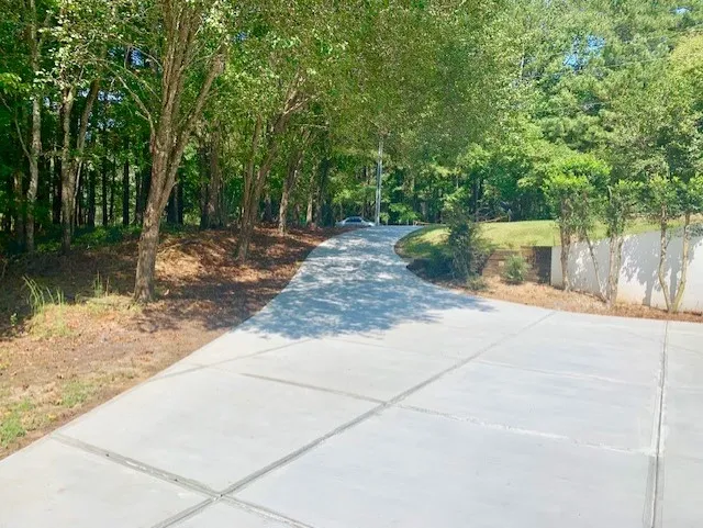 A large concrete driveway as seen from the garage, looking towards the street