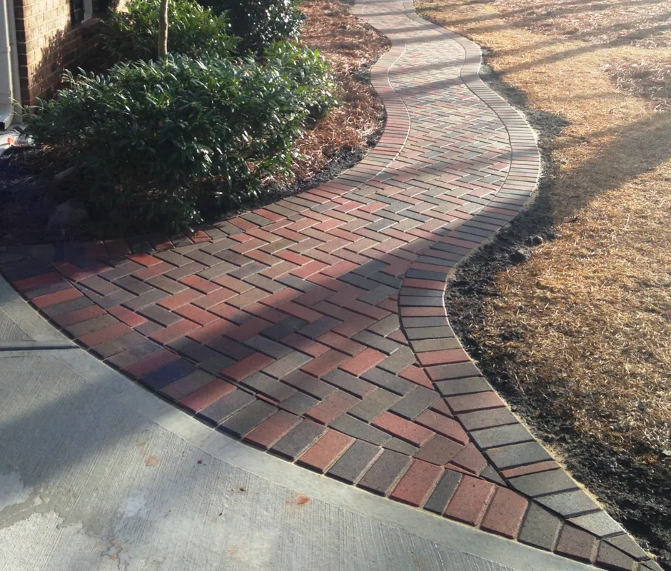 An elegant paver pathway made from dark red and brown brick pavers