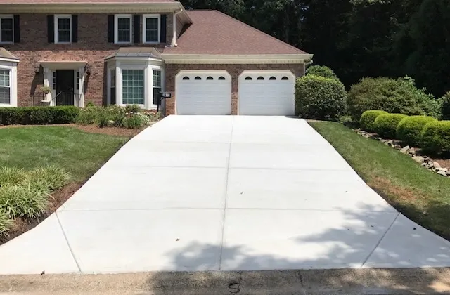 A wide concrete driveway sloping up to a two-car garage